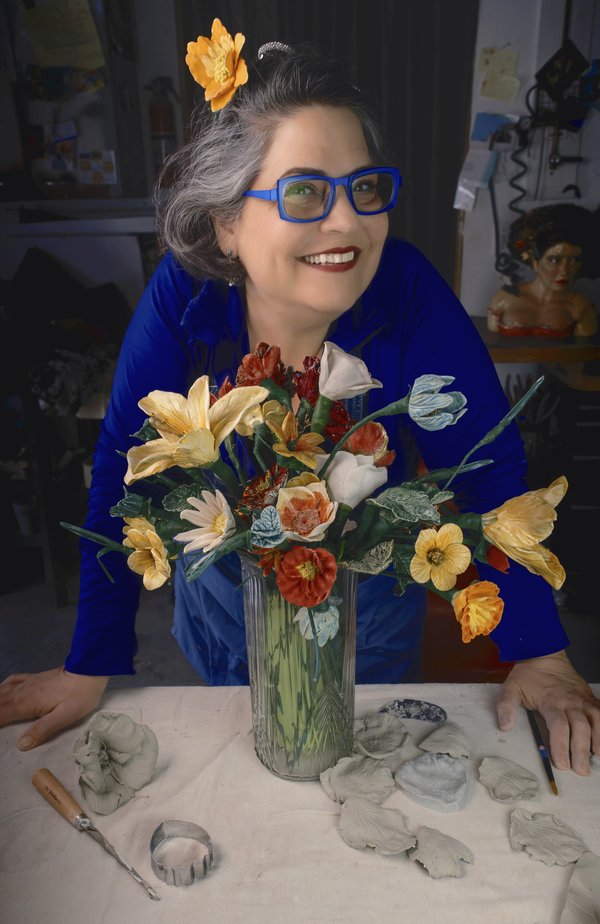 8.Bernadette Esperanza Torres in blue glasses with her handmade ceramic flowers in a vase in her art studio_Photo Credit Stone Addams - Audrey Kesler