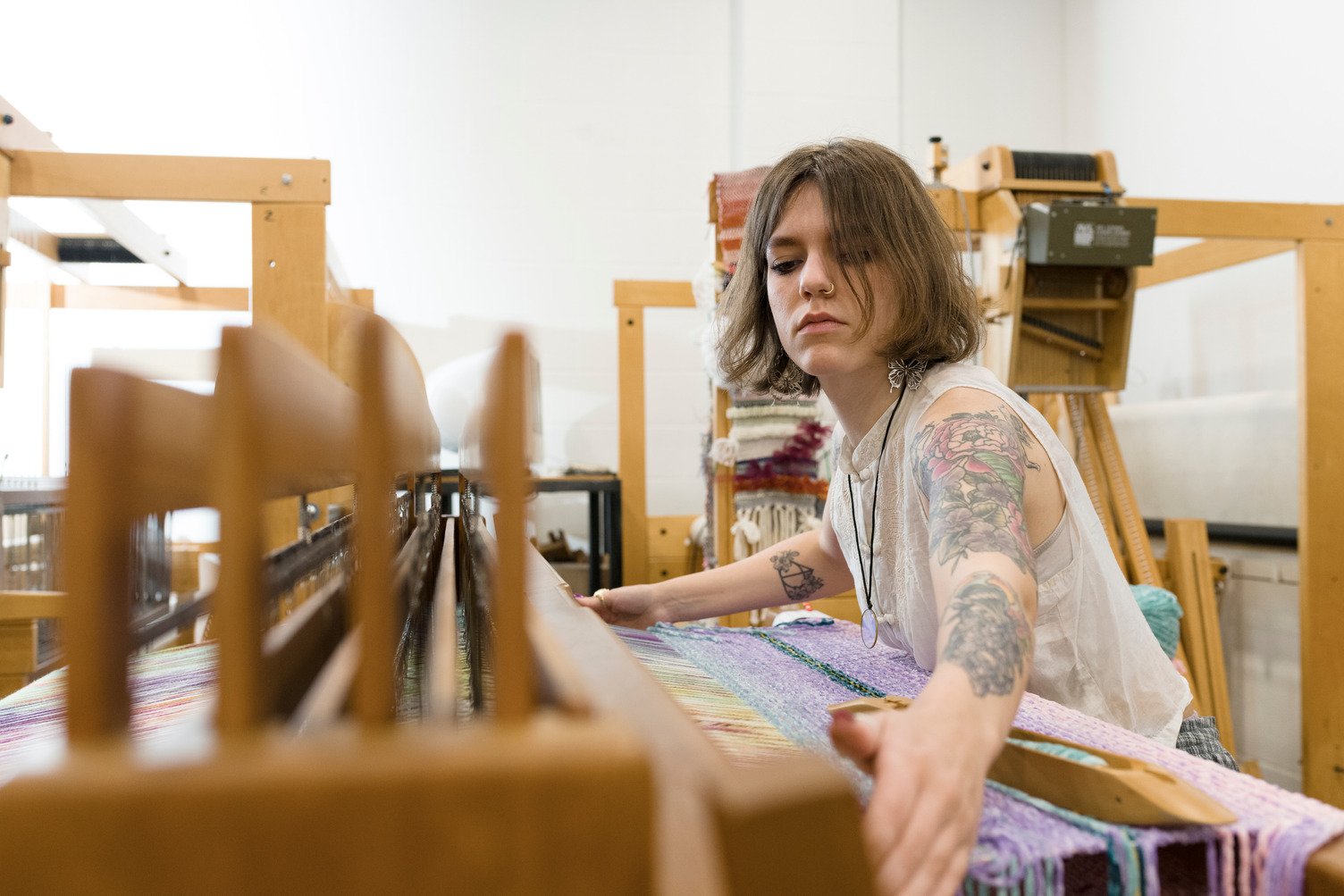 KCAI Fiber student Olivia Thompson levels off her workspace in the Fiber Studio