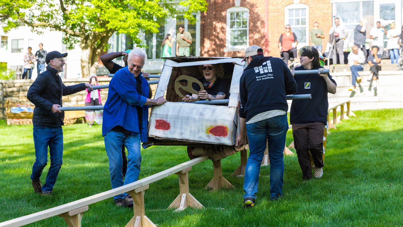 KCAI students, faculty and alumni compete in Rail Day, a creation from Professor Steve Mayse’s Image and Form Exploration class. Participants create wacky cars out of cardboard and glue and attempt to ride them down a 80-foot long, 18-inches high rail.