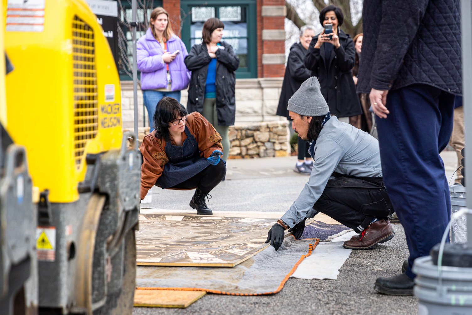 Visiting artists Tara Takizawa works with students to prepare for a print creation during the annual Road Roller Day outside Vanderslice Hall