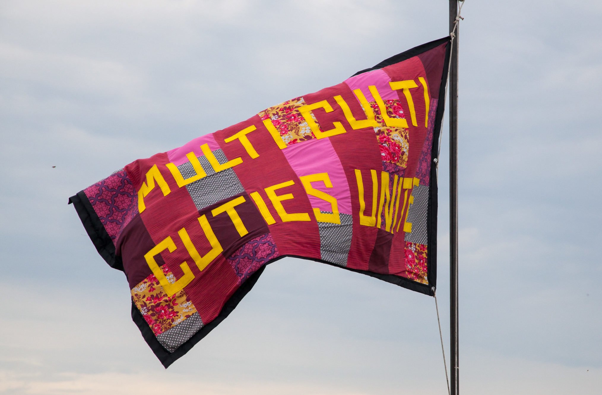 Flying flag that reads Multi Culti Cuties Unite